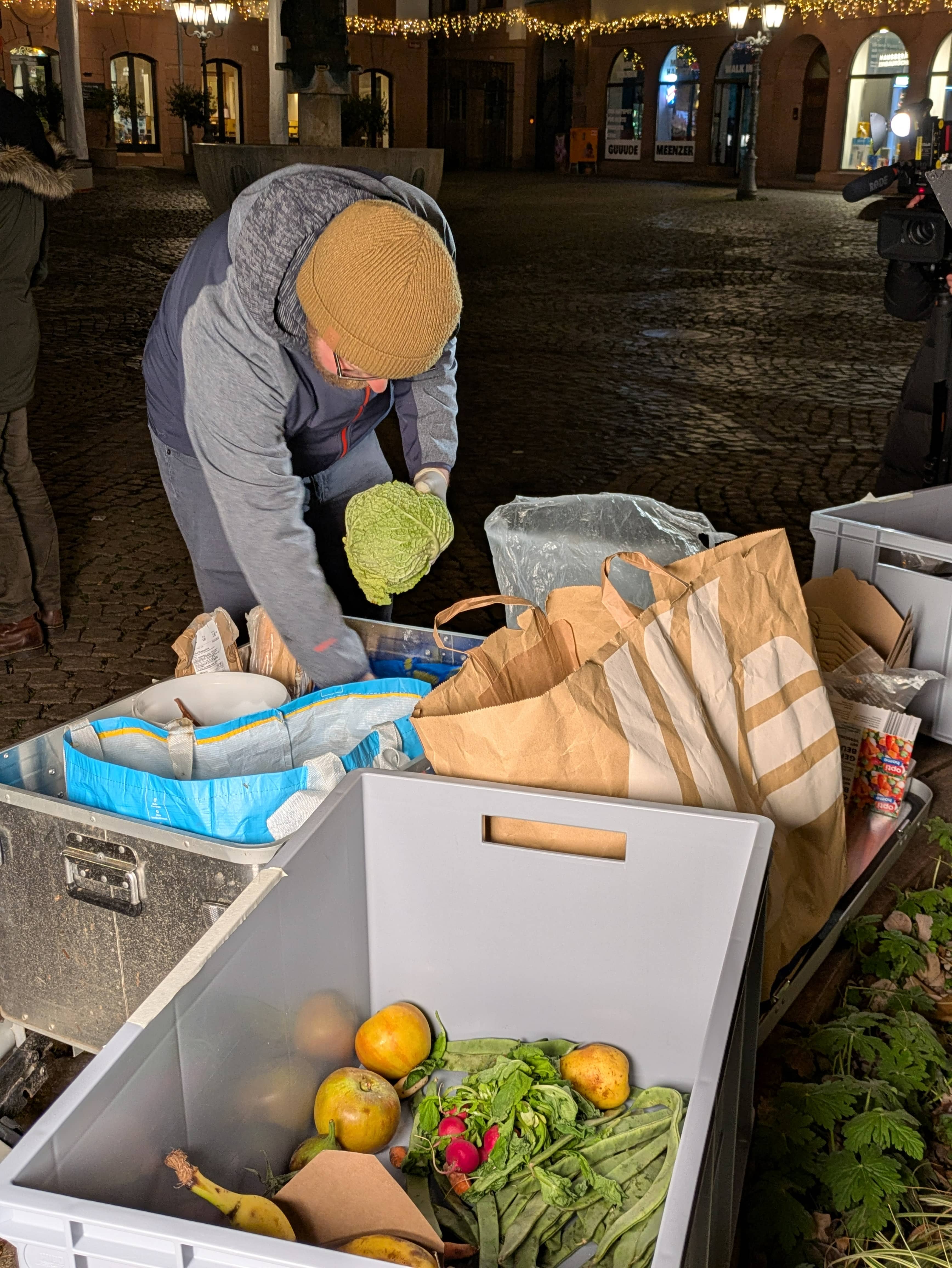 Mann durchwühlt die Lebensmittelkisten